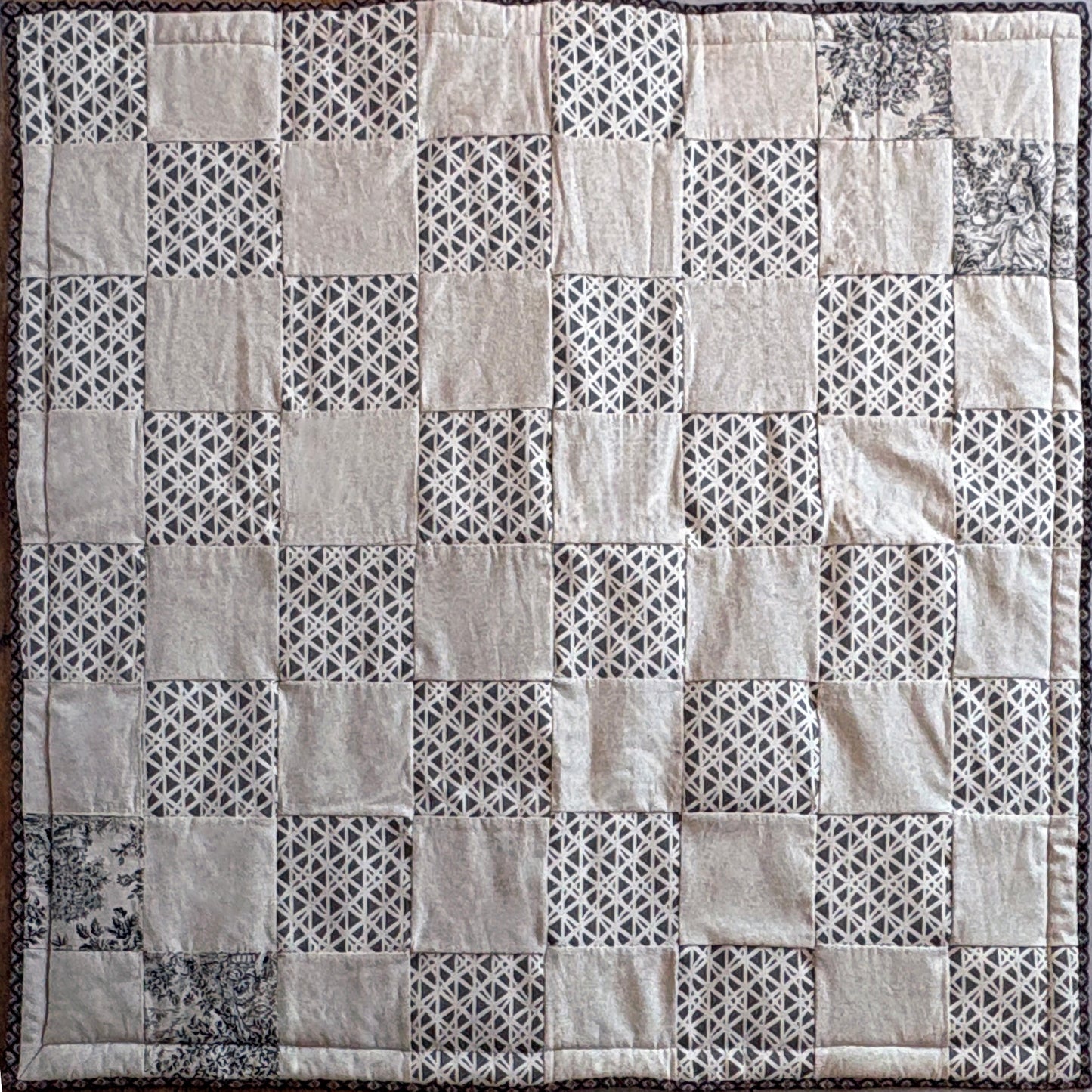 Patchwork picnic blanket with geometric patterns in neutral shades of beige & brown