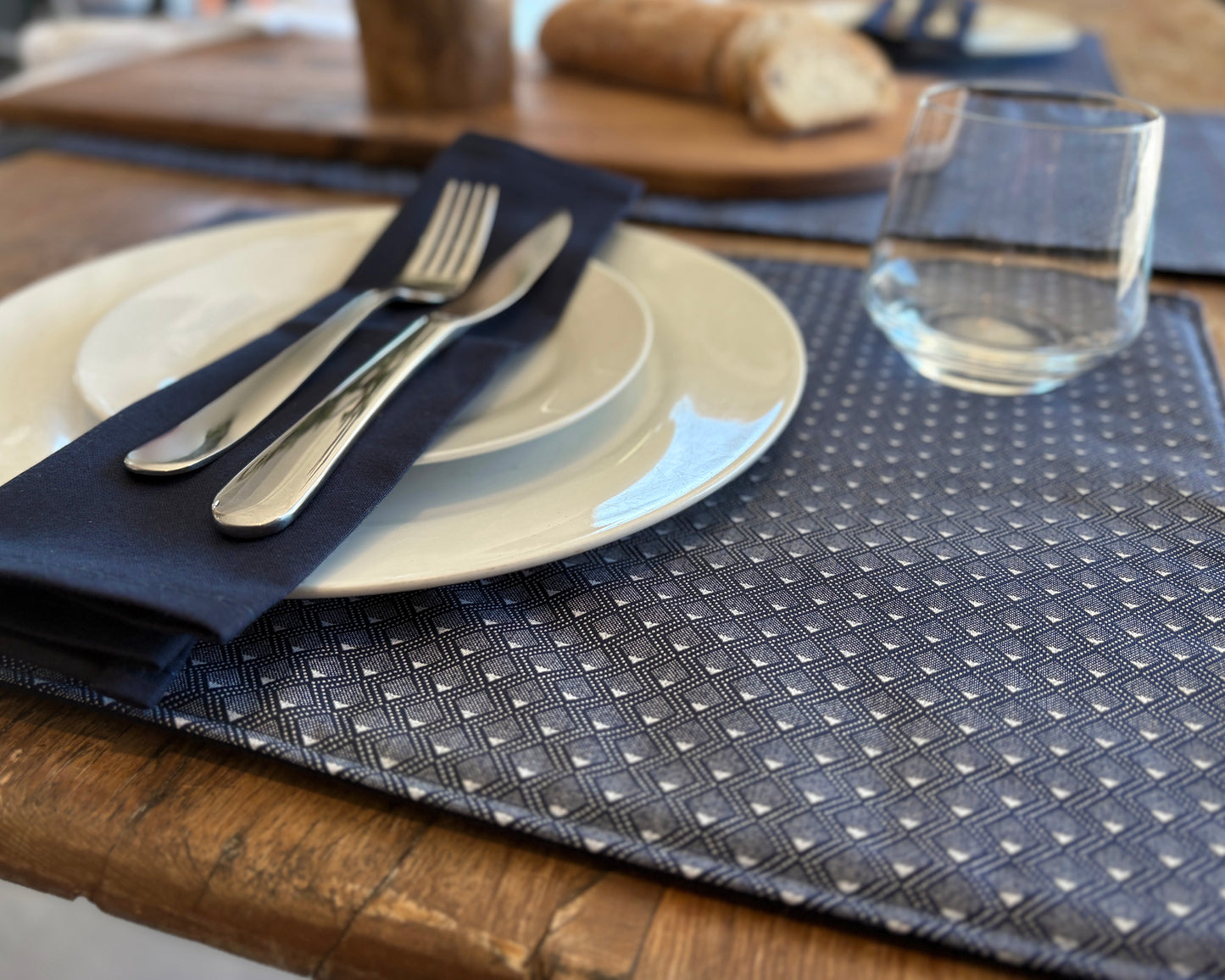 Close up of Blue ShweShwe Fabric placemats with White Diamond print on wooden table.