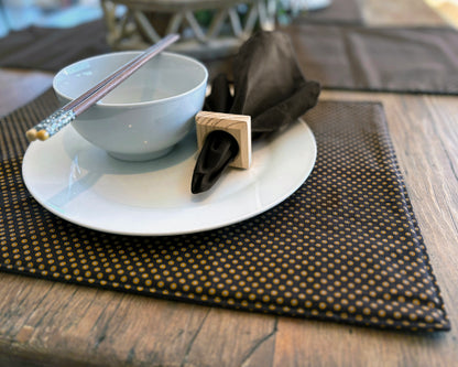 Close up of Brown Shwe Shwe Fabric placemats with White & Yellow Dots print on wooden table.