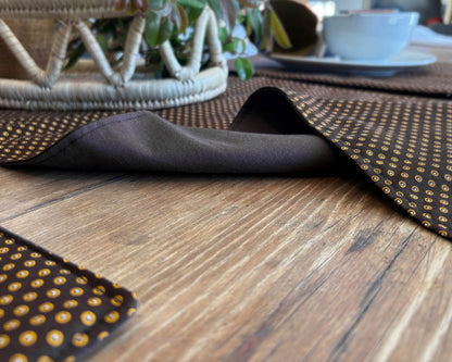 Brown Shwe Shwe lined fabric Table runner on wooden table. Yellow Dots traditional print on brown fabric.