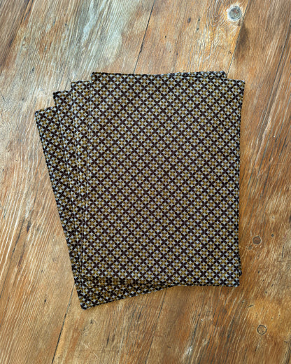 Brown Shwe Shwe Fabric placemats with White & Yellow Geometric print on wooden table.
