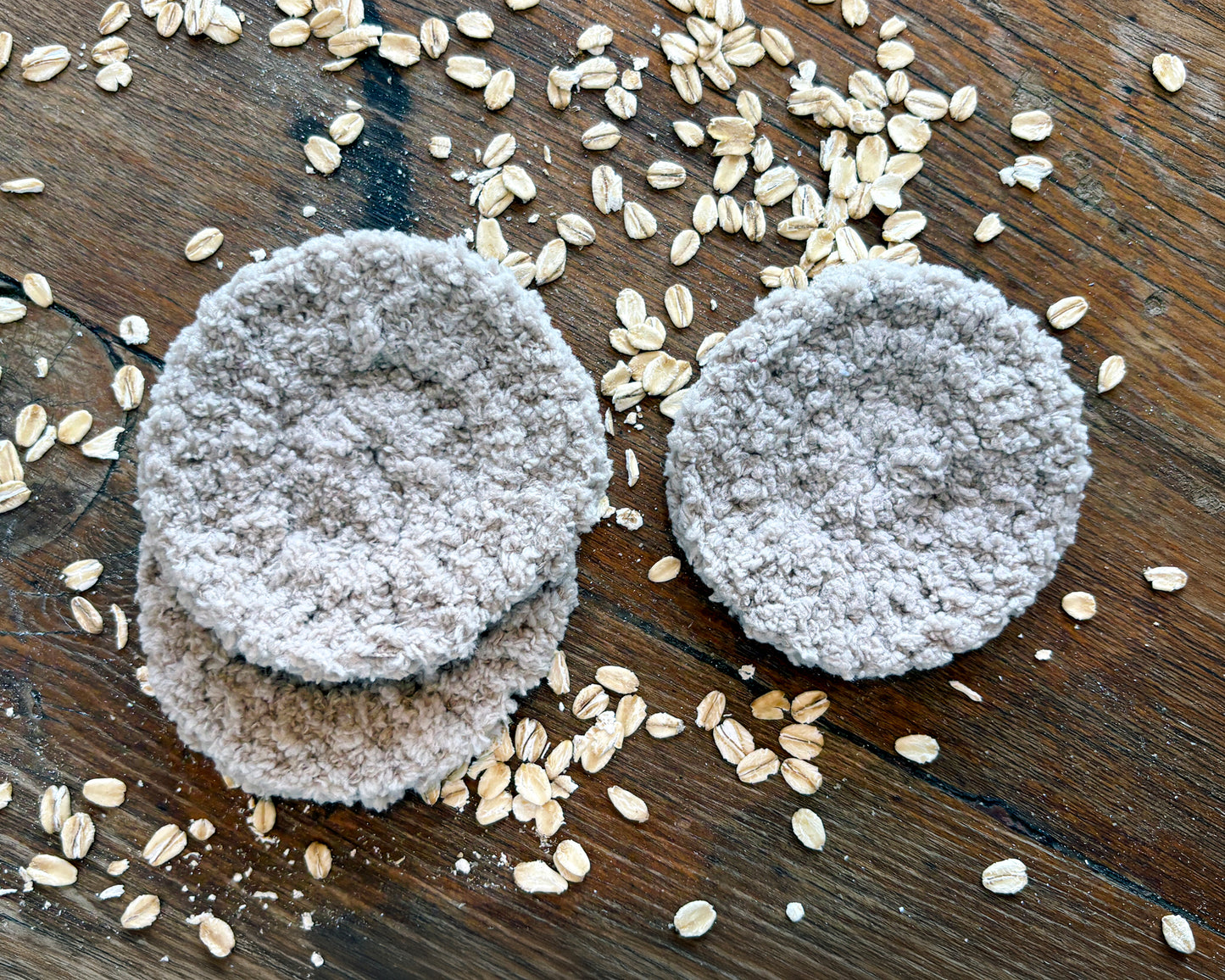 Reusable round crochet face scrubbies on a wooden surface