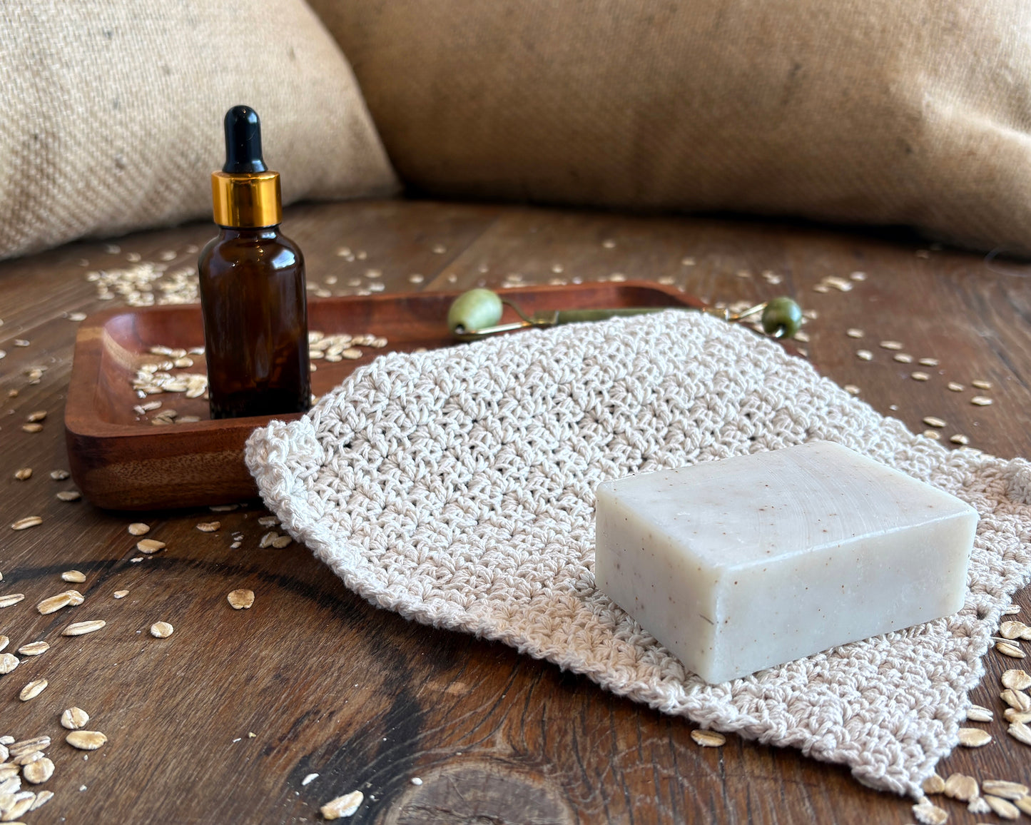 Bar of soap on a natural white crochet cloth with bathroom accessories