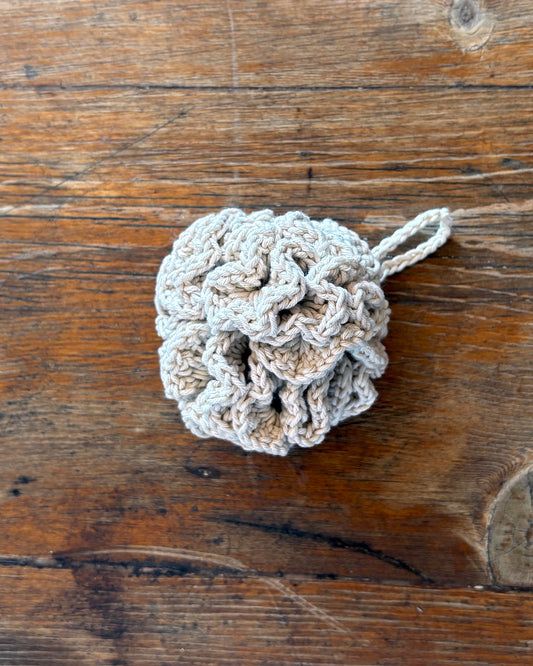 Natural White Crocheted loofah on a wooden surface