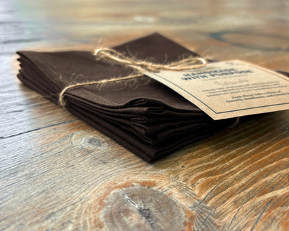 Folded brown fabric napkin on a wooden surface