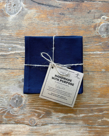 Navy blue napkin set of 4 on a wooden surface.