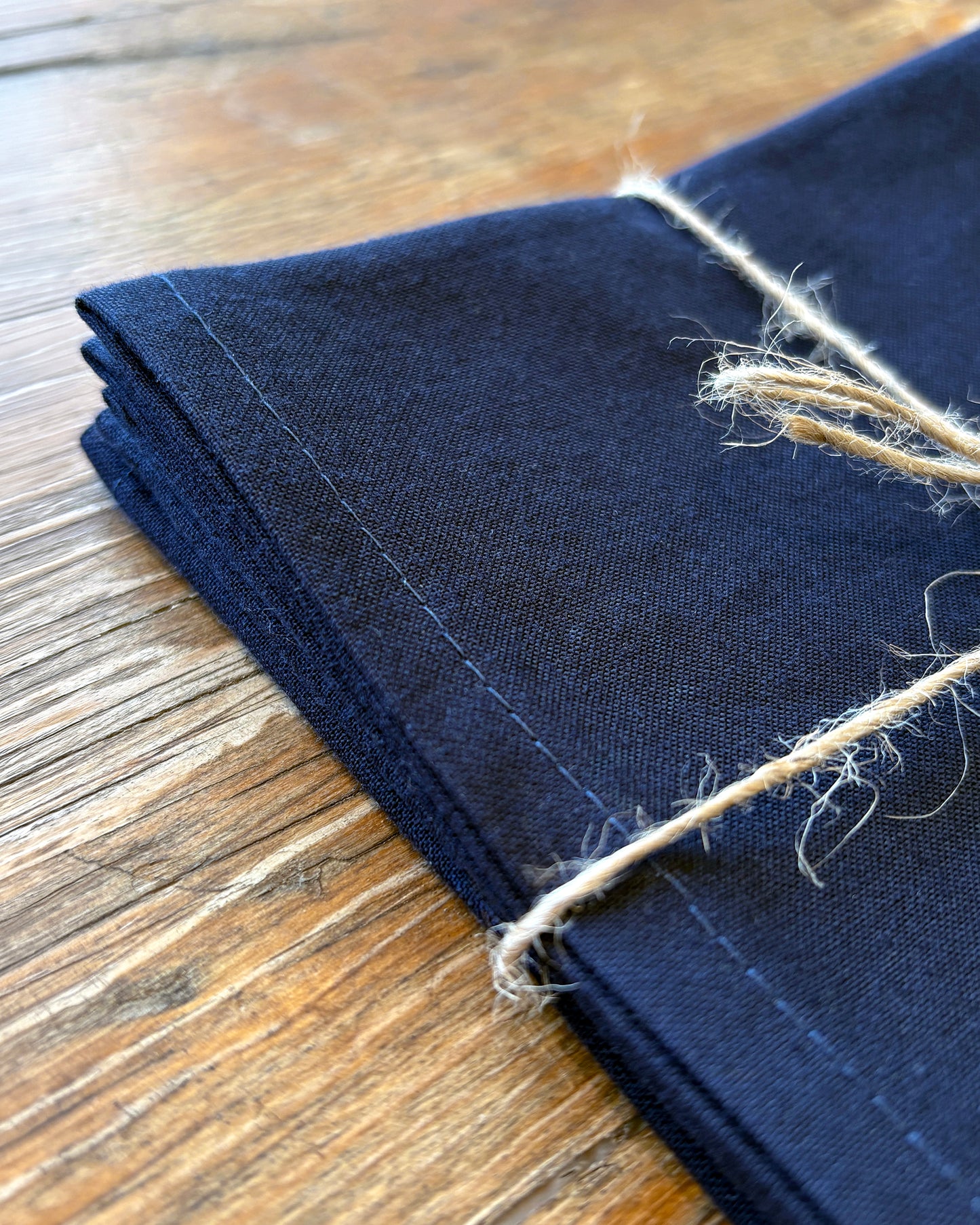 Close-up of a folded navy blue fabric on a wooden surface