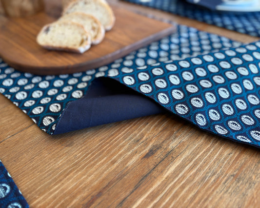 Navy Shwe Shwe lined fabric Table runner on wooden table. Protea print on fabric.